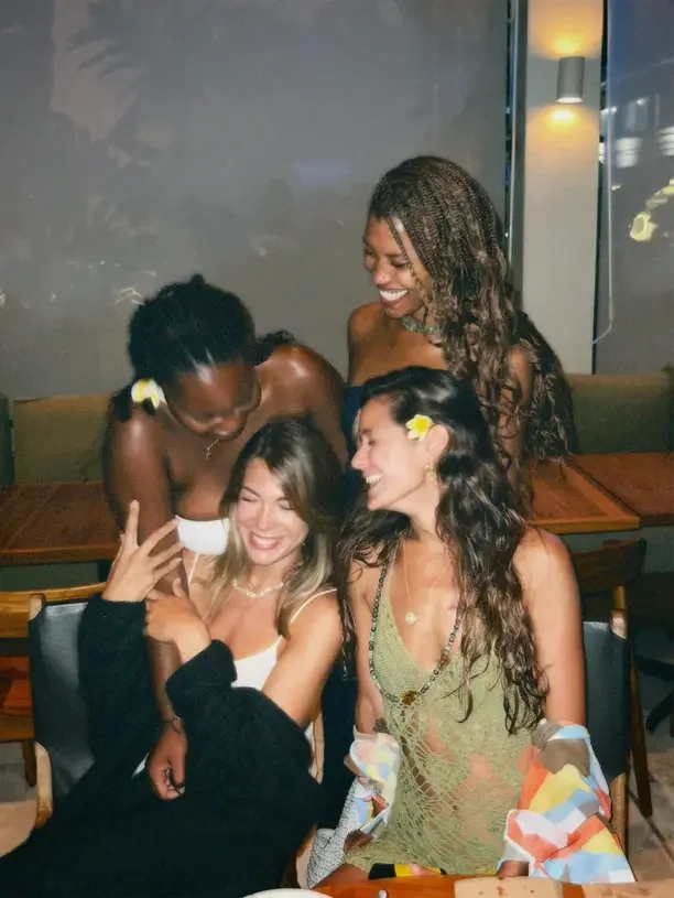 Best Christmas gift ideas for a 19 year old female with friends laughing together at a holiday party.
