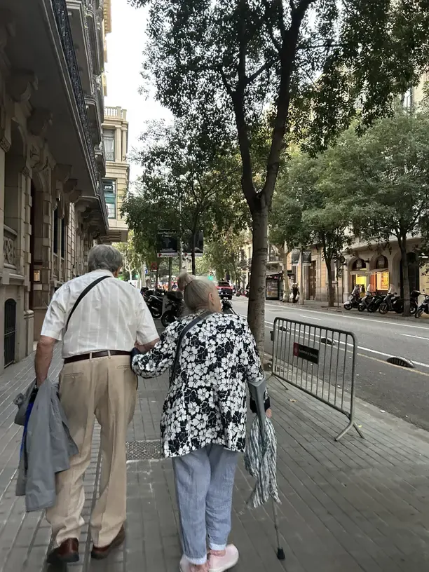 Best Christmas gifts for elderly parents with an older couple walking arm in arm down a city street.