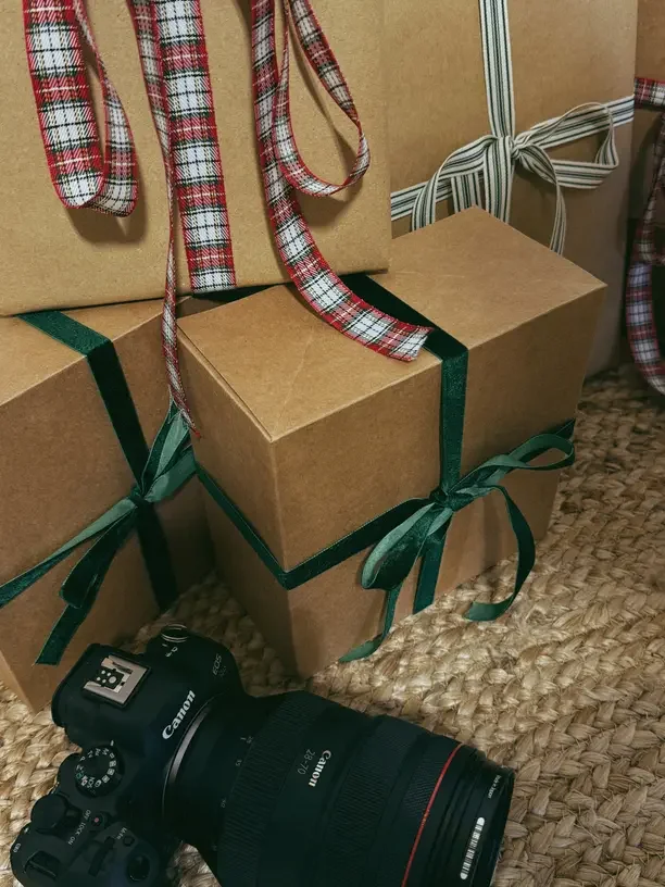 Best gifts to mail for Christmas with kraft boxes wrapped in plaid and green ribbon.
