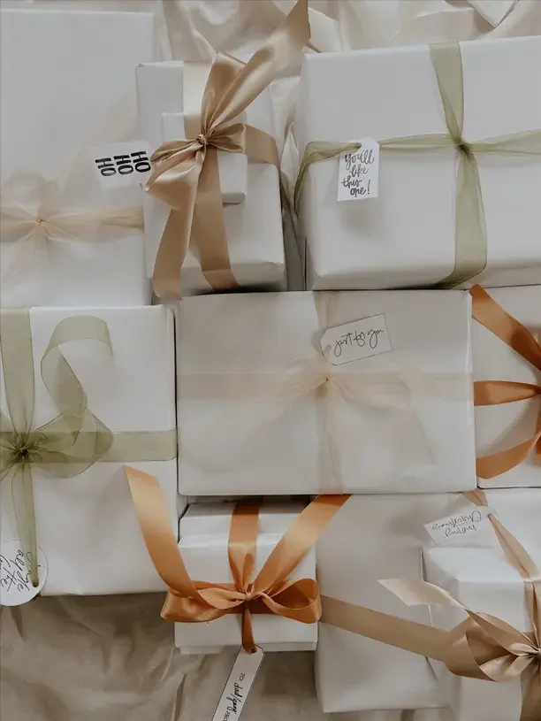 Christmas gift games with a pile of white wrapped gifts tied with gold ribbon.