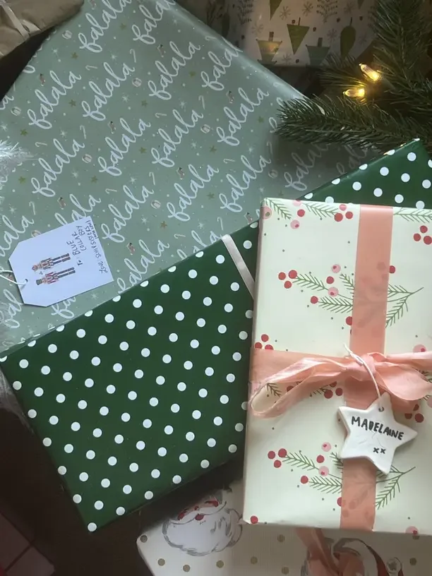 Christmas gifts for brother in college with presents wrapped in green and polka dot paper.