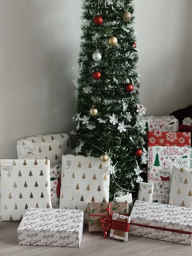 Christmas gift ideas for parents with wrapped presents under a decorated Christmas tree.