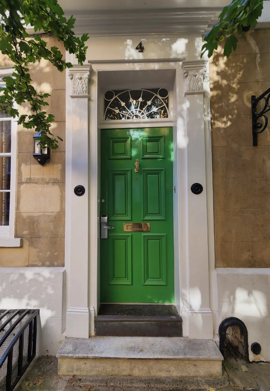 green painted front door with ironwork