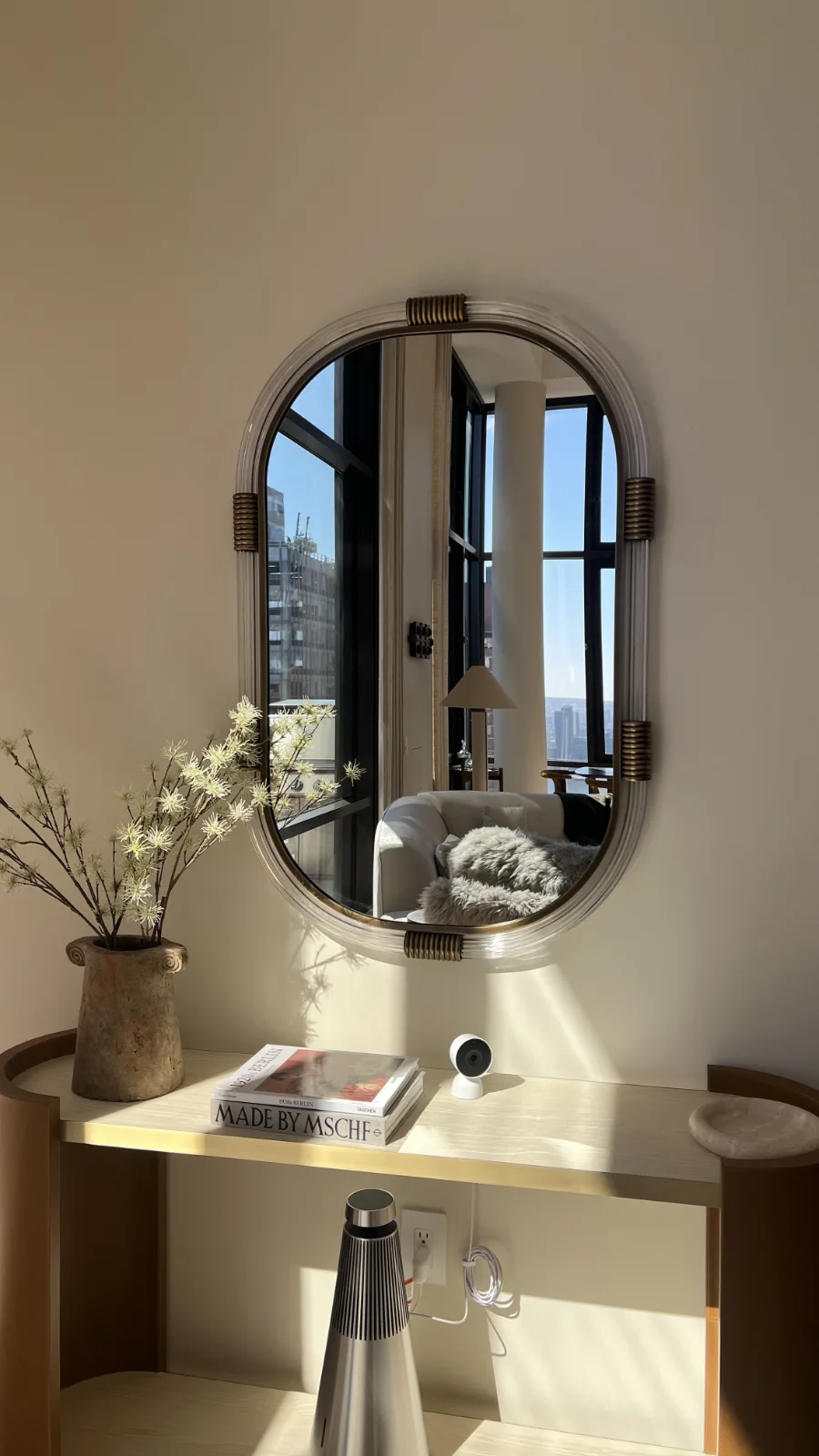 oval mirror over an entry console