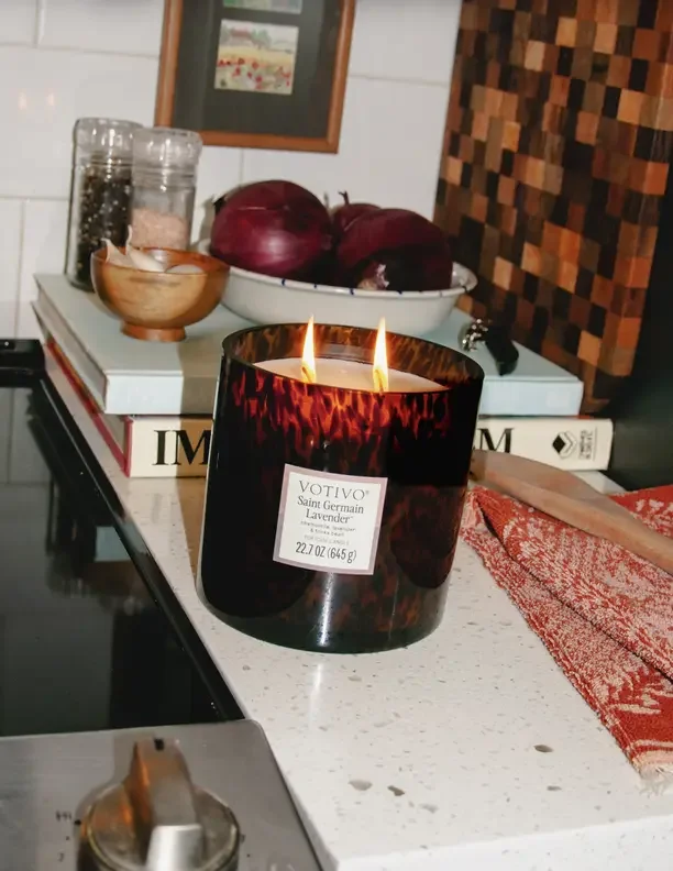 How to make your house smell like Christmas with a red glass candle burning on a kitchen counter.