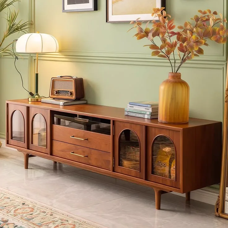 Teak mid century media console against a green wall