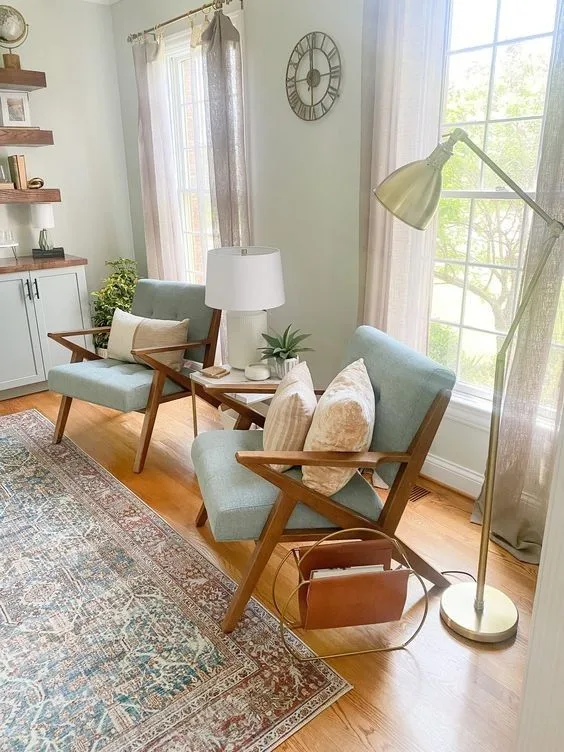 Two teal mid century armchairs in a sunny living room