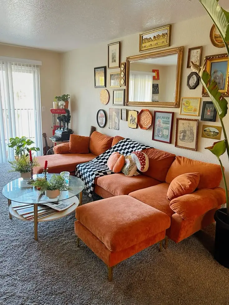 Burnt orange velvet sectional with a gallery wall