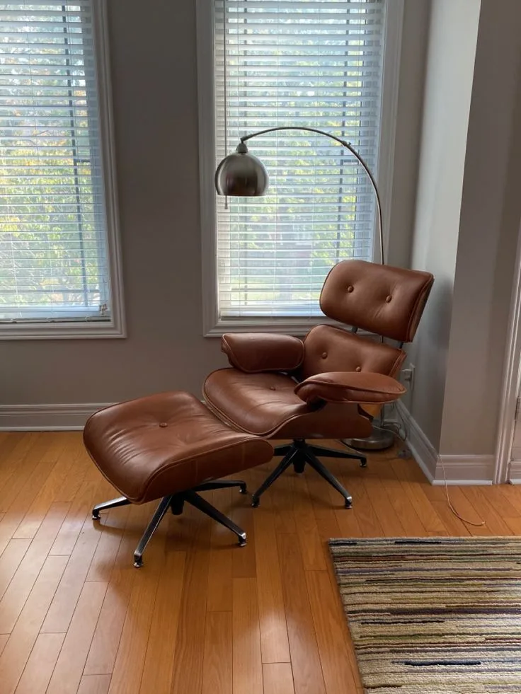 Brown leather lounge chair and ottoman with an arc floor lamp