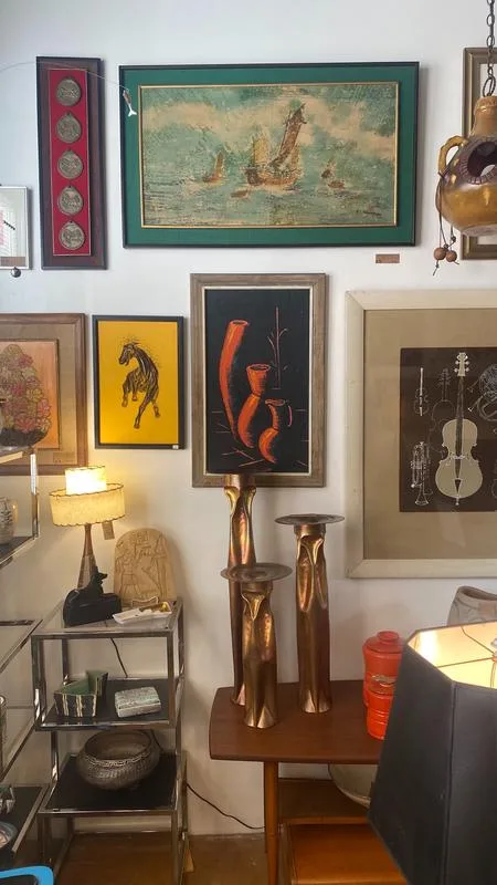 mid century modern furniture in a vintage room with framed art and a bar cart