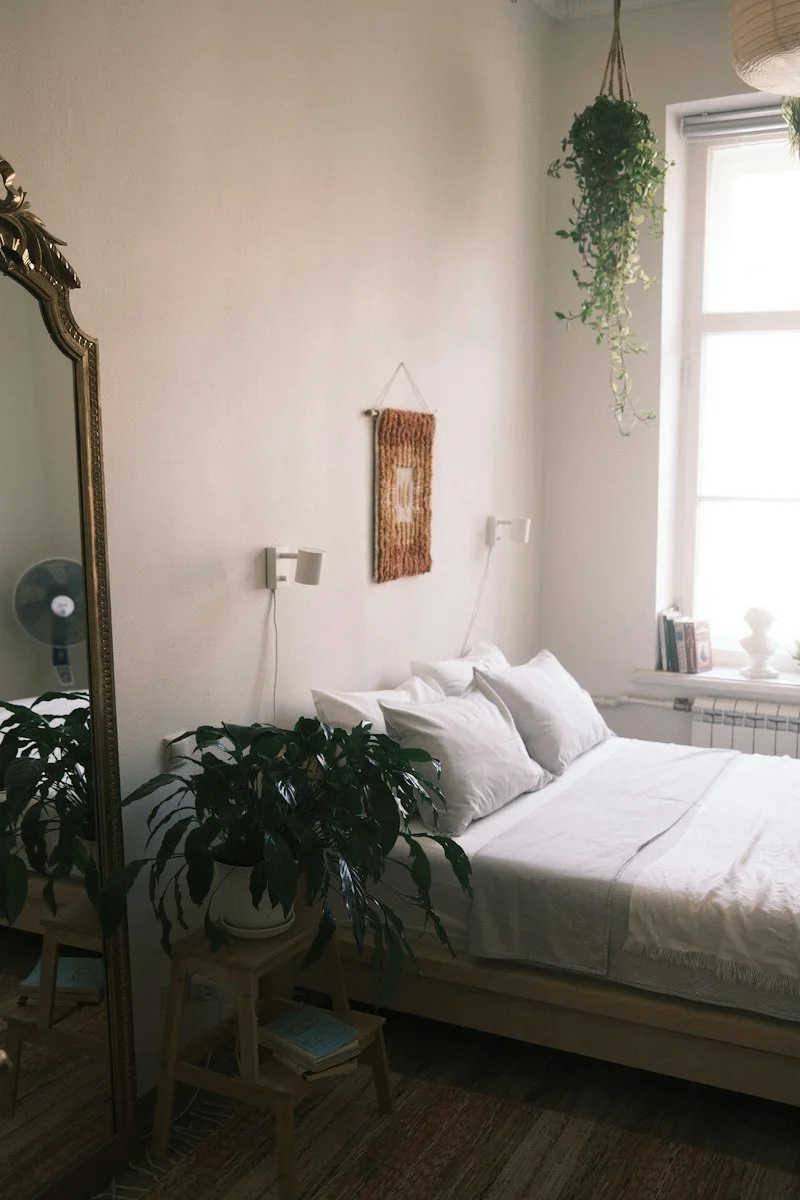 Warm neutral bedroom with cream linen bedding, wood furniture and soft natural light