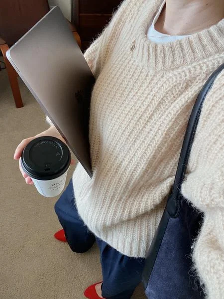 stores like loft workwear look with a cream knit sweater, coffee and a laptop bag
